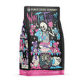 The front of a 12 ounce bag of Bones Coffee Company What the Fluff coffee. Its flavor is berry cotton candy, and it has a skeleton angrily stuffing teddy bears with cotton candy on the art.